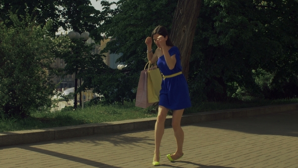 Elegant Woman Twisting Her Ankle While Walking on Street