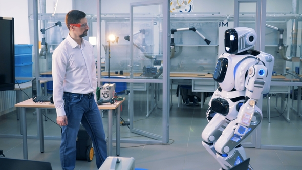 Male Engineer Is Pushing a Human-like Cyborg Away Two Times