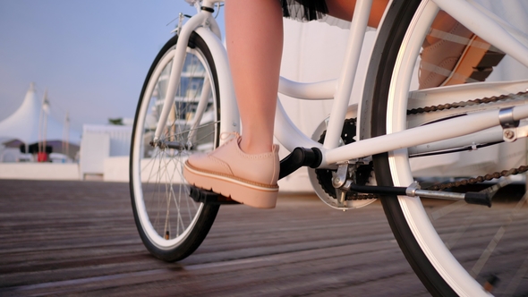 View of Young Stylish Girl in Pink Platform Shoes Brogues and Skirt Cycling on Vintage Bike