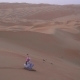 Teenage Girl Rolls on Sandboard on the Slope of a Dune in the Rub Al Khali Desert United Arab - VideoHive Item for Sale