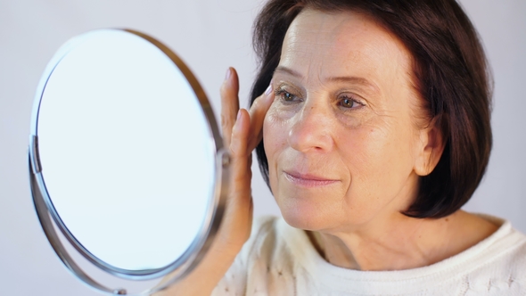 Elderly Woman Stroking the Skin on the Face