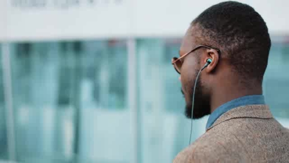 African American Businessman Listens To the Music and Dances While He Walks Near the Office Building