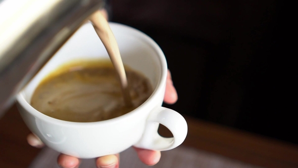 Pouring Milk Into Cup of Coffee