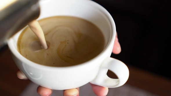 Pouring Cream Into Cup of Coffee