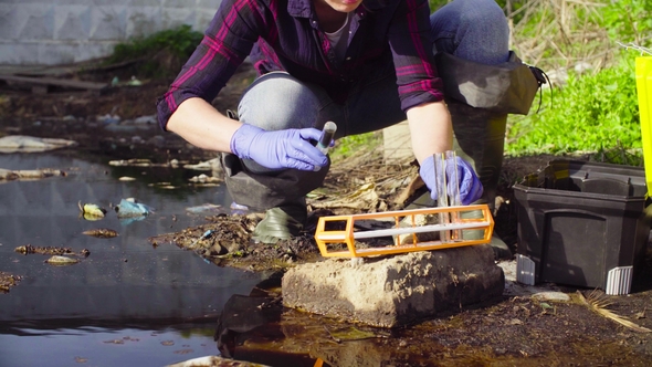 Hands of Ecologist Taking Samples of the Water.