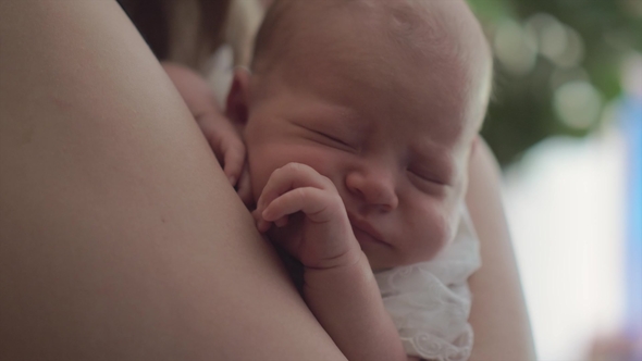Newborn Baby Sleeping in Mums Arms