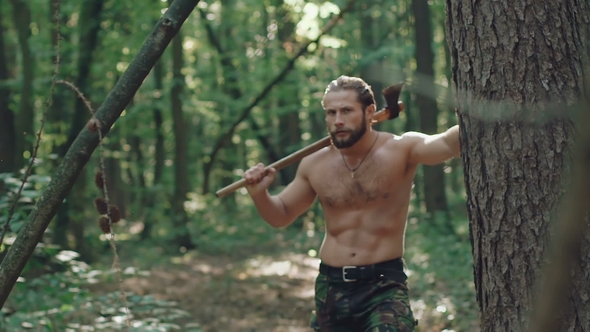 Portrait of Handsome Bearded Man with Ax in the Forest