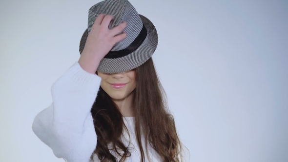 Pretty Young Girl Plays with Hat and Wears on Head with Cute Smile