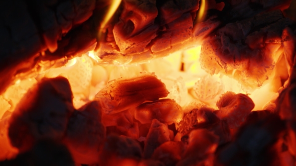 Fire Sparks Moving on Dark Black Background Coming from Brightly Burning Warm