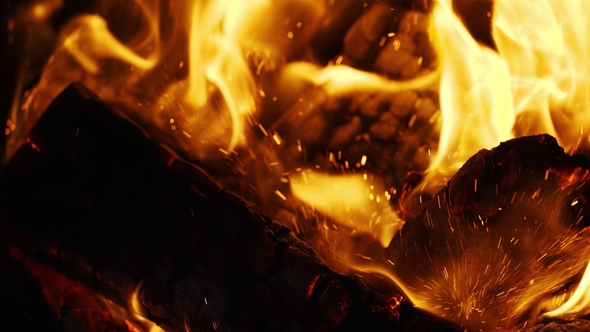 Fire Sparks Moving on Dark at Black Background Coming From Brightly Burning Warm