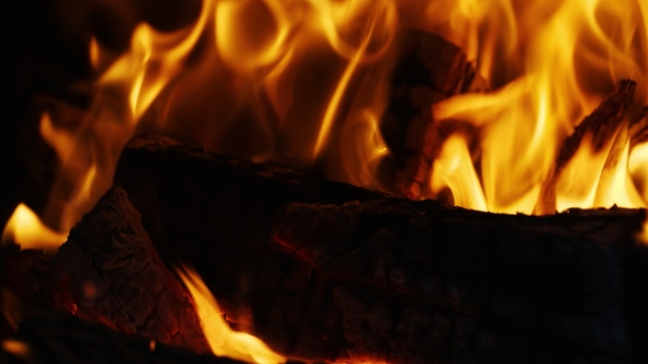 Fire Sparks Moving on Dark at Black Background Coming From Brightly Burning Warm