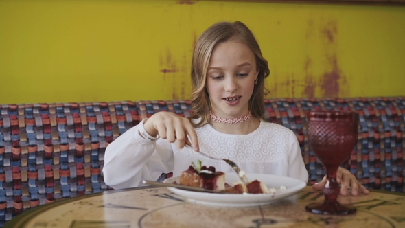 Pretty Young Girl Eating Tasty Dessert and Looking at Window.