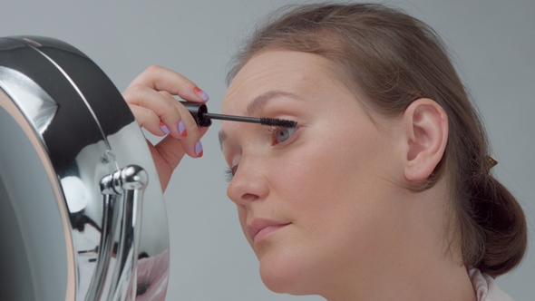 Caucasian Woman with Mirror with Ring Light with No Makeup Look Examine Her Skin and Makes Facial