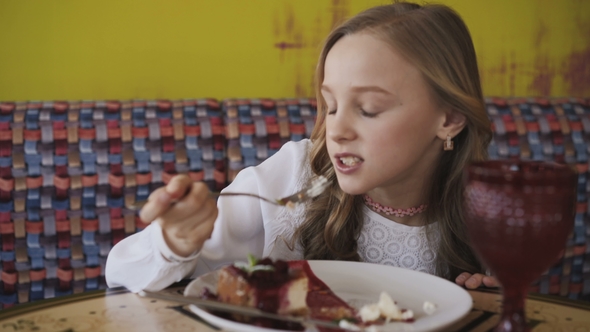 Pretty Young Girl Eating Tasty Dessert and Looking at Window