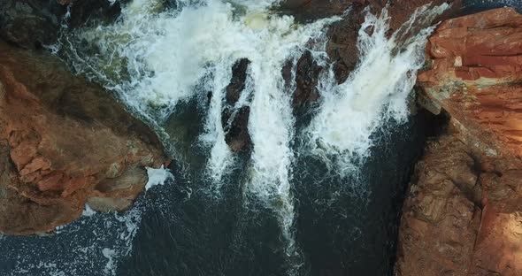 Foamed waterfall waters between the rocks.