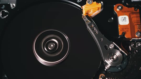 Opened Hard Disk Drive with Spinning Platter. Move of Writing Magnetic Head