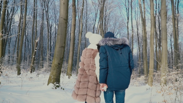 Couple Walking Through the Winter Forest