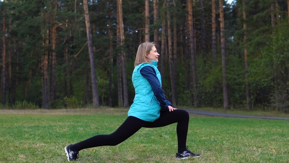 Girl Is Training in the Park on the Lawn.