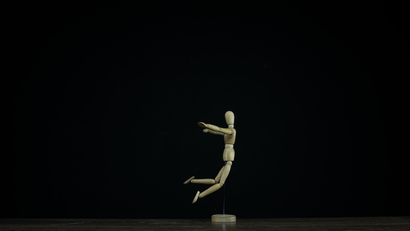 Falling Wooden Figure Dummy in Studio on Black Background Rotating