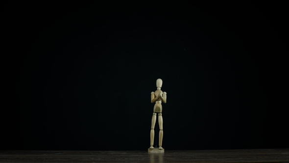 Wooden Figure Dummy Applauds in Studio on Black Background