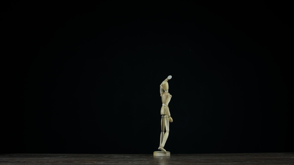 Wooden Figure Dummy in Studion on Black Background