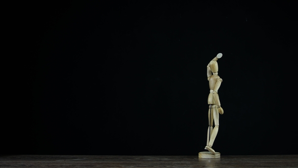 Wooden Figure Dummy in Studio on Black Background