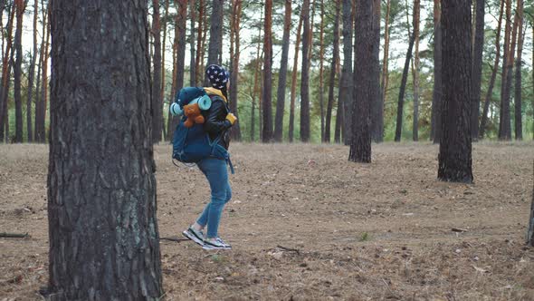 Happy Tourist with Backpack on Forest Pine Trees