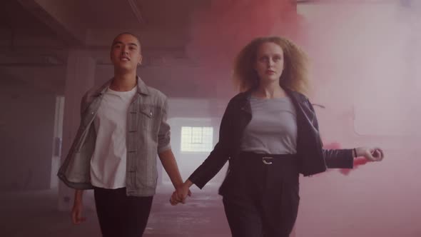 Fashionable young man and woman in an abandoned warehouse