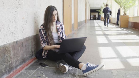 Student Girl in a College sitting with Laptop