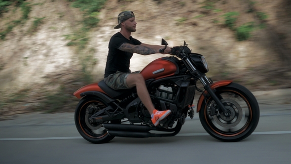 Young Man Without Helmet Riding His Orange Motorcycle on a Highway, Stabilizer