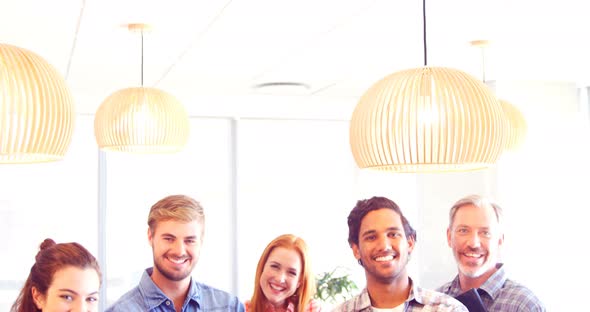 Business colleagues standing with arms crossed in office