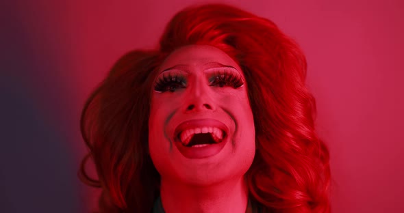 Drag queen smiling on camera with red light inside studio - Lgbtq concept