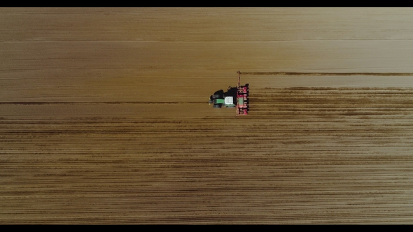 Aerial of Tractor on Harvest Field Ploughing Agricultural Field.