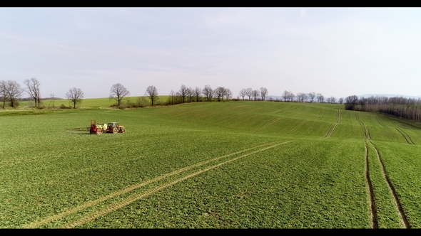 Tractor Spray Fertilize on Field with Chemicals in Agriculture Field