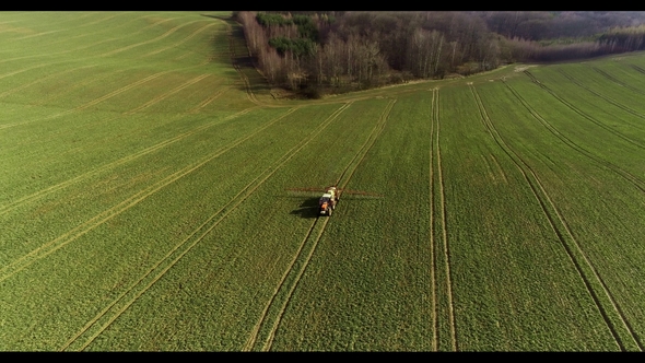 Tractor Spray Fertilize on Field with Chemicals in Agriculture Field