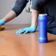 Girl in a Gray Sweater and Blue Gloves Washes a Wooden Table with a Yellow Rag - VideoHive Item for Sale