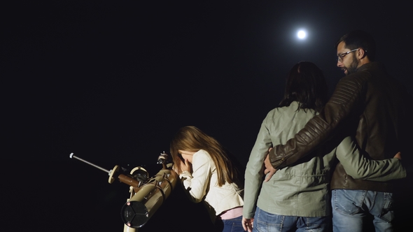 Happy Family Watching the Moon in a Telescope at Night