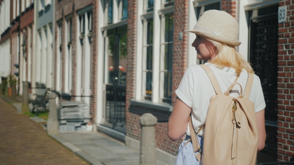 The Tourist Walks Along the Beautiful Street of the Old European City. Uses Smartphone, Rear View