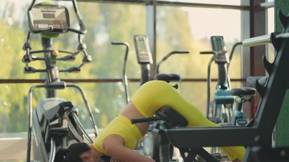 Young Beautiful Hispanic Woman Performs Hyperextension in the Gym