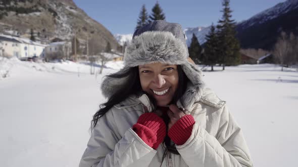 Cheerful Young African American Girl is Cold Having Fun on a Winter Day in the Mountains