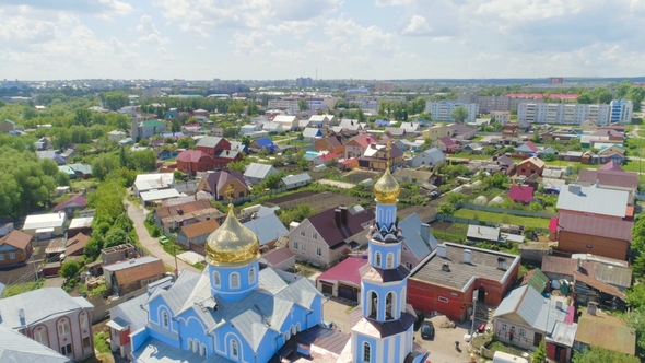 Orthodox Church with Sparkling Domes Against City Buildings
