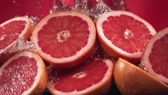 Slow Motion Shot of Grapefruit Water Splashing Through Grapefruit Slices