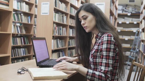 Student Girl in a Library with Laptop
