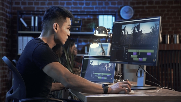 Ethnic Man Editing Video on Computer