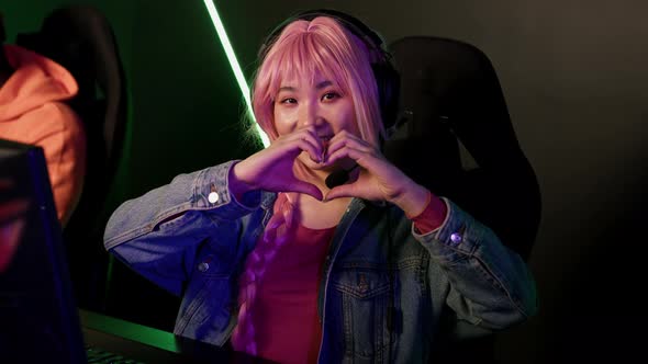 Teenage Asian Pinkhaired Girl Wearing Headset Using Professional Gaming Setup Focused on Playing