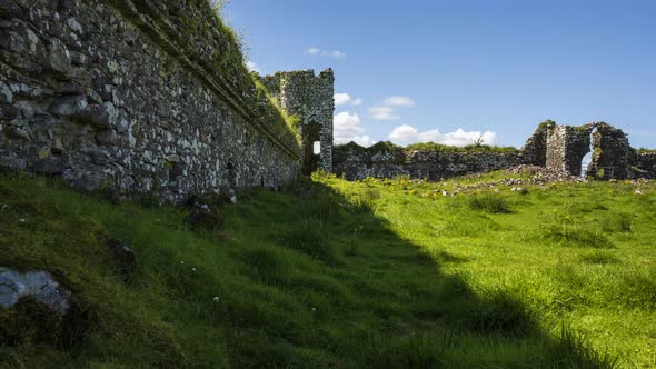 Time lapse of abandoned castle ruins in rural grass landscape of Ireland on a sunny summer day. alt