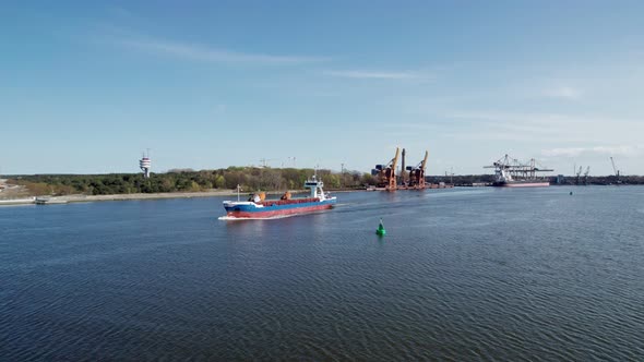 An aerial view of a cargo ship leaves the port.