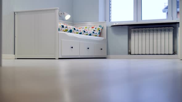 A Floor Level View on a White Robotic Vacuum Cleaner at Work