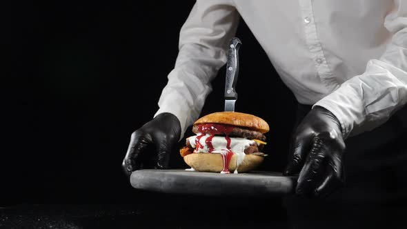 Fast Food Restaurant Food Concept. Chef Serves Prepared Tasty Burger. Delicious Cheeseburger with