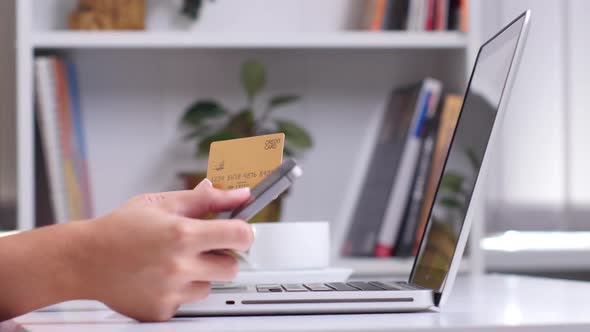 Online Shopping. Female Hand Holding Gold Credit Card and Shopping Online. Close Up